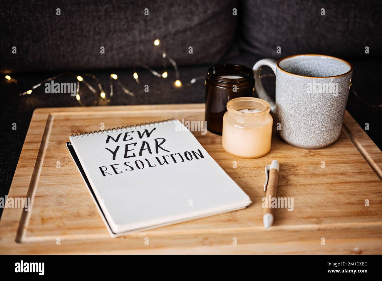 Ziele für das 2023. Jahr, Auflösung Neujahr Text in offenem Notizblock neben Tasse und Kerzen auf dem Sofa zu Hause. Beginnen Sie ein neues Leben, planen und setzen Sie Ziele Stockfoto