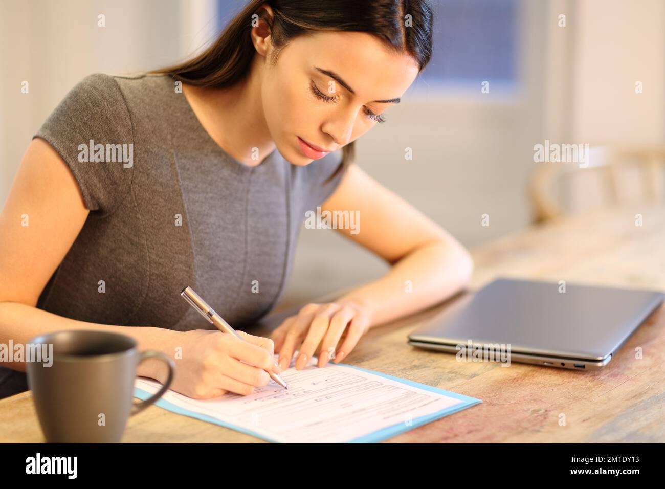 Geschäftsfrau, die das Formular ausfüllt, auf einem Tisch im Büro Stockfoto