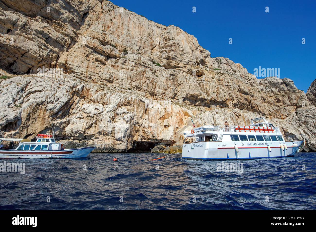 Ausflugsboote vor der felsigen Küste von Capo Caccia mit Grotta Nereo Höhle, Alghero, Sardinien, Italien, Europa Stockfoto