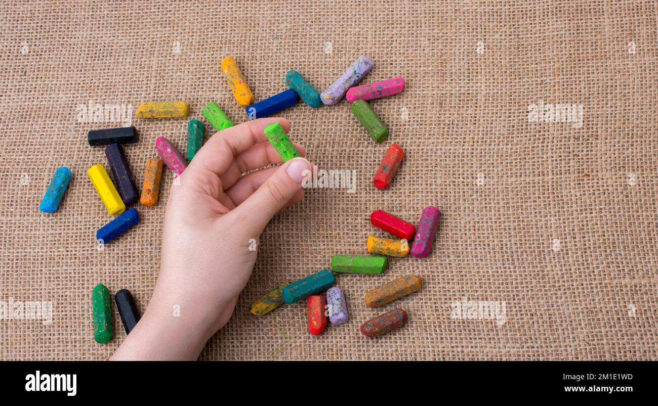 Benutzte Farbstifte und eine Hand, die einen hielt Stockfoto