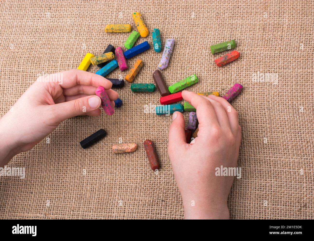 Benutzte Farbstifte und eine Hand, die etwas hielt Stockfoto