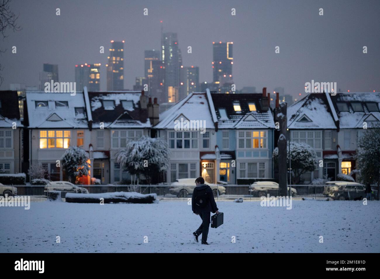 Nach niedrigen Temperaturen und Schneefällen im Süden Londons im Ruskin Park im Jahr SE24, am 12.. Dezember 2022, in London, England, geht ein Pendler an Wohnhäusern vorbei. Stockfoto