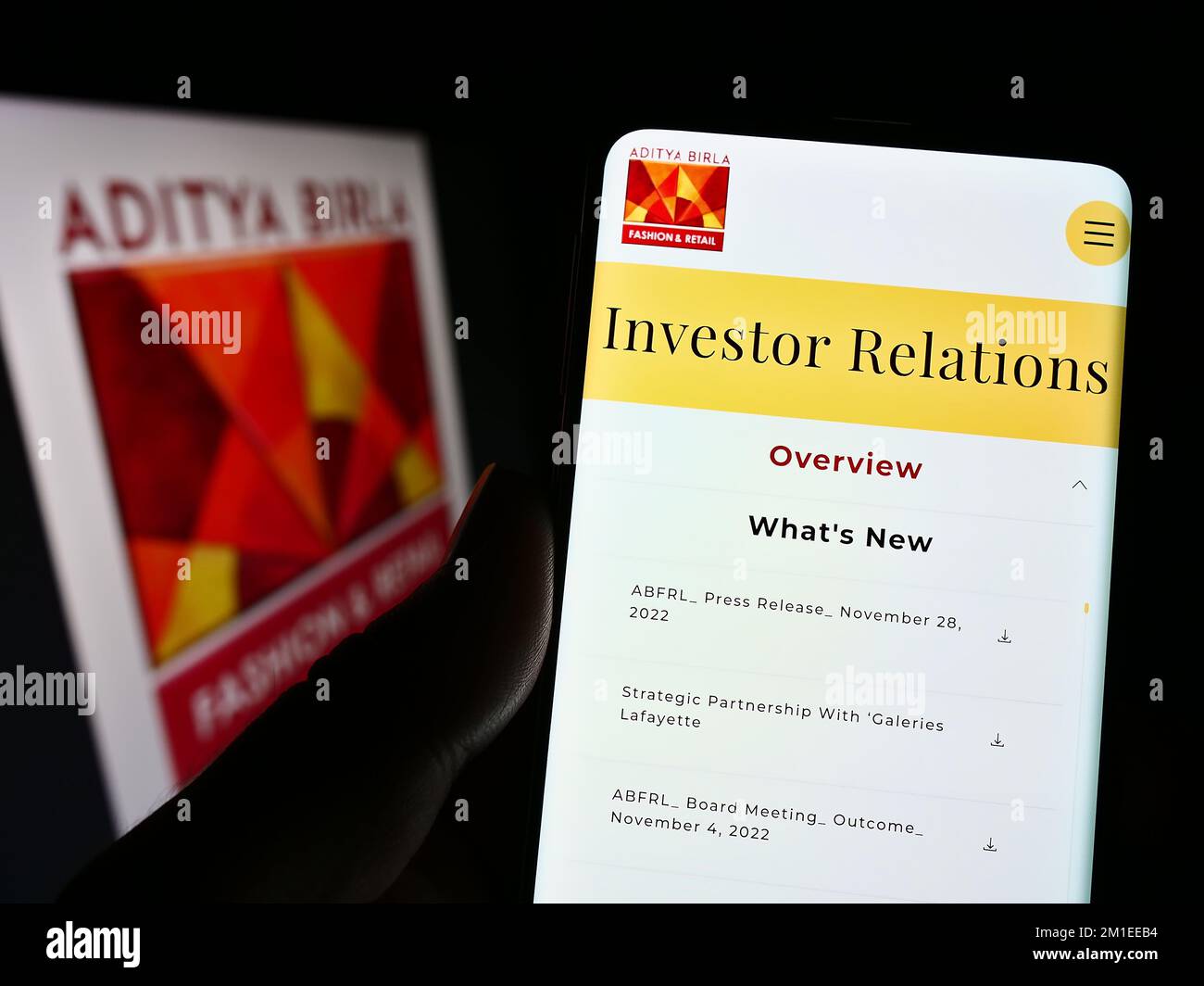 Person mit Smartphone und Webseite von Aditya Birla Fashion and Retail Limited (ABFRL) auf dem Bildschirm mit Logo. Konzentrieren Sie sich auf die Mitte des Telefondisplays. Stockfoto