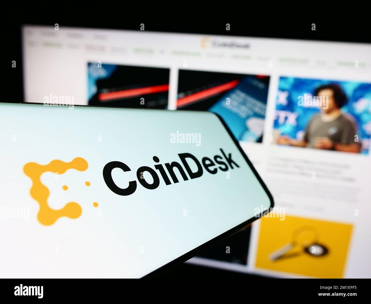 Smartphone mit Logo der amerikanischen kryptografischen Nachrichtenfirma CoinDesk Inc. Auf dem Bildschirm vor der Business-Website. Konzentrieren Sie sich auf die Mitte des Telefondisplays. Stockfoto
