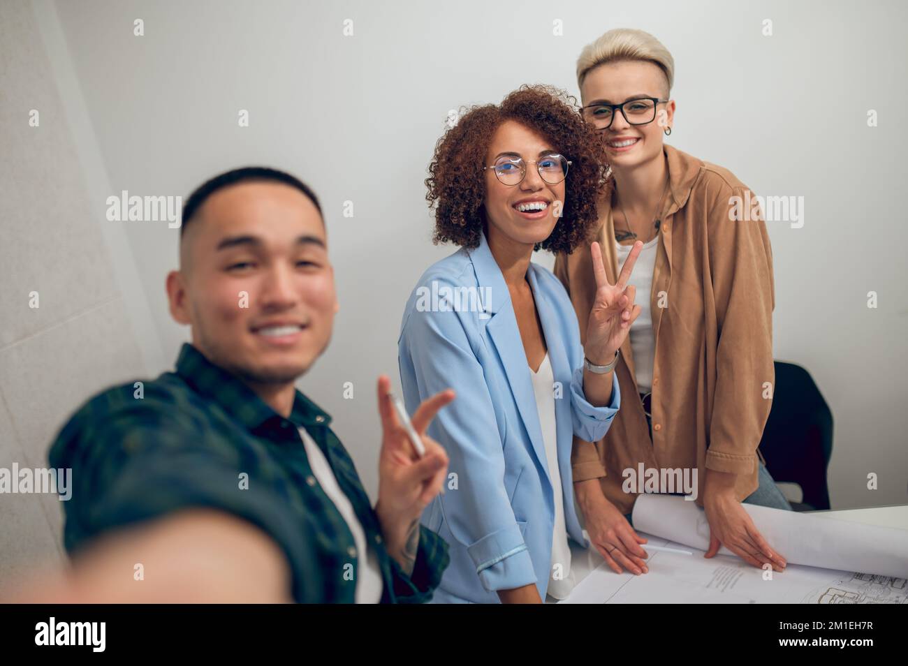 Fröhliches Architekturteam, das Selfies bei der Mitarbeiterversammlung macht Stockfoto