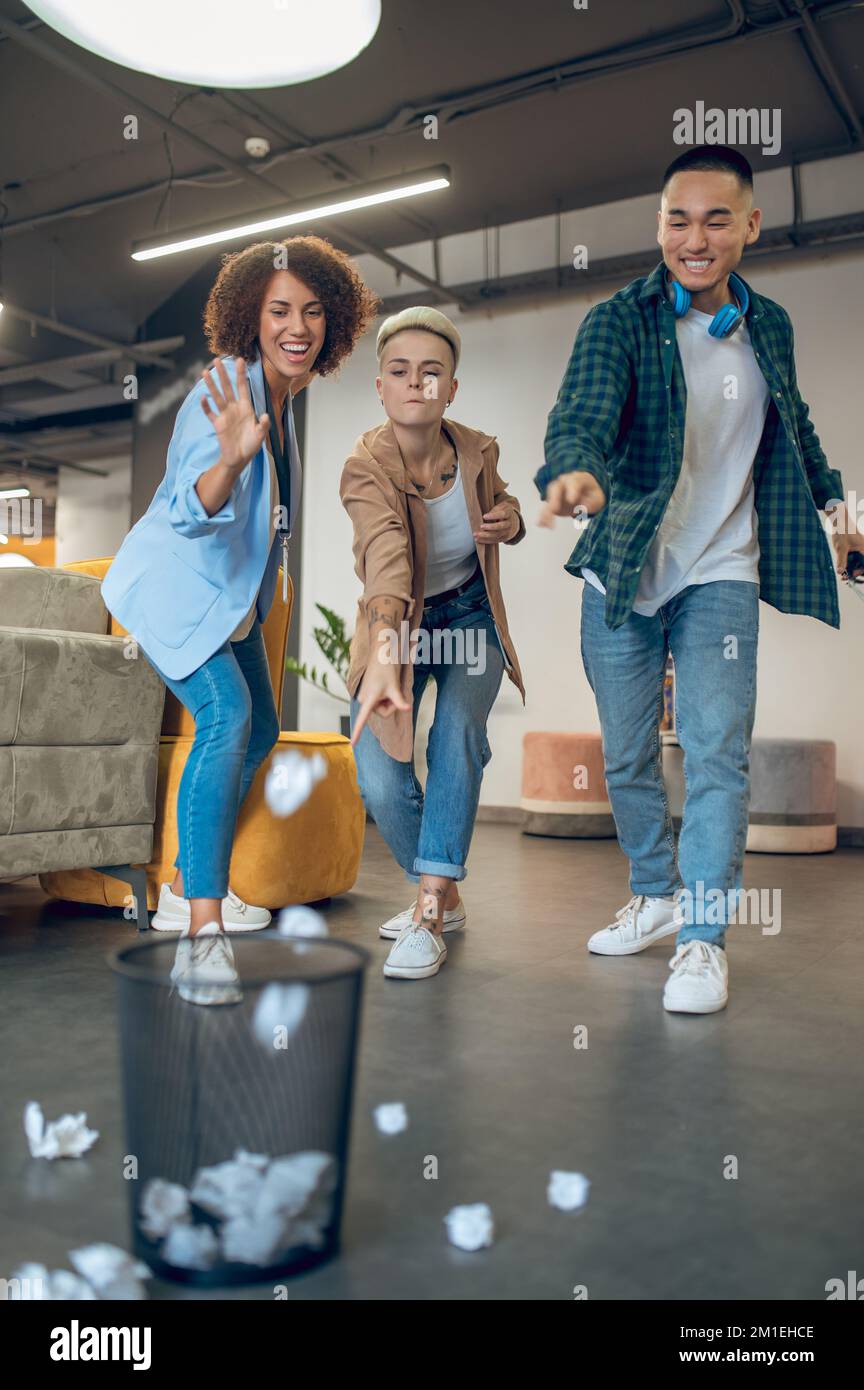 Drei Büroangestellte entsorgen Müll Stockfoto