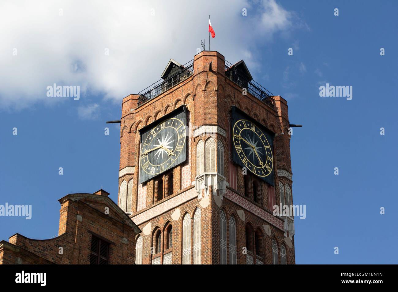 Uhrenturm des Rathauses von Ratusz Staromiejski in Torun, Polen, mit polnischer Flagge Stockfoto