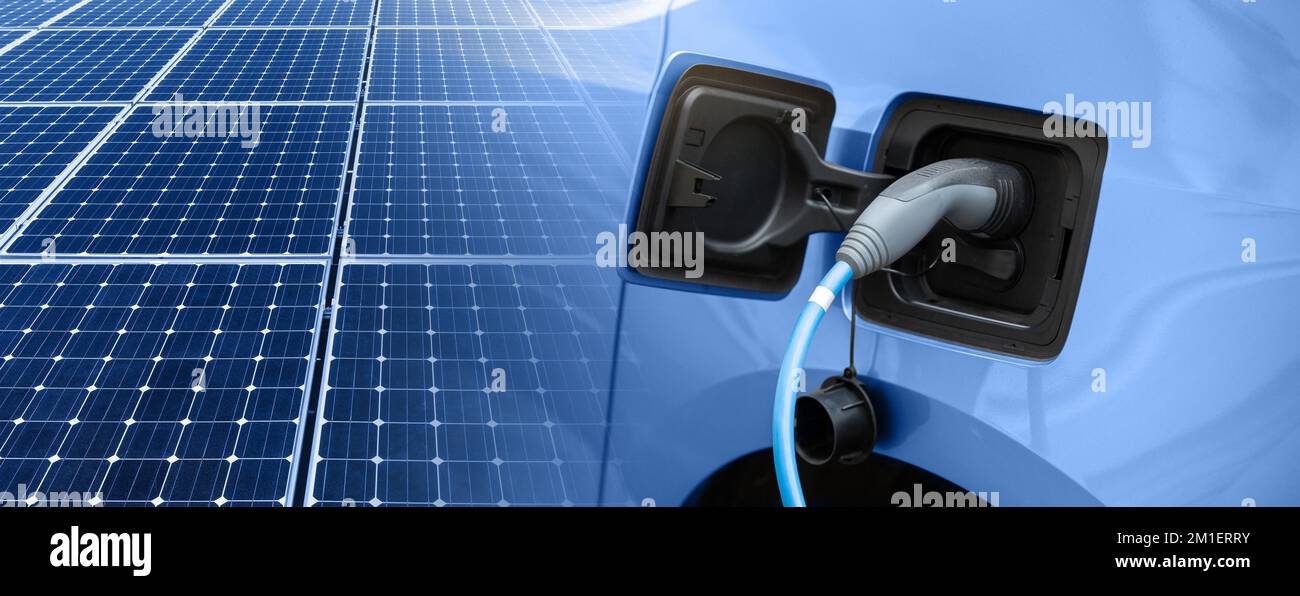 Nahaufnahme eines Elektroautos mit Ladekabel und Solarmodulen Stockfoto