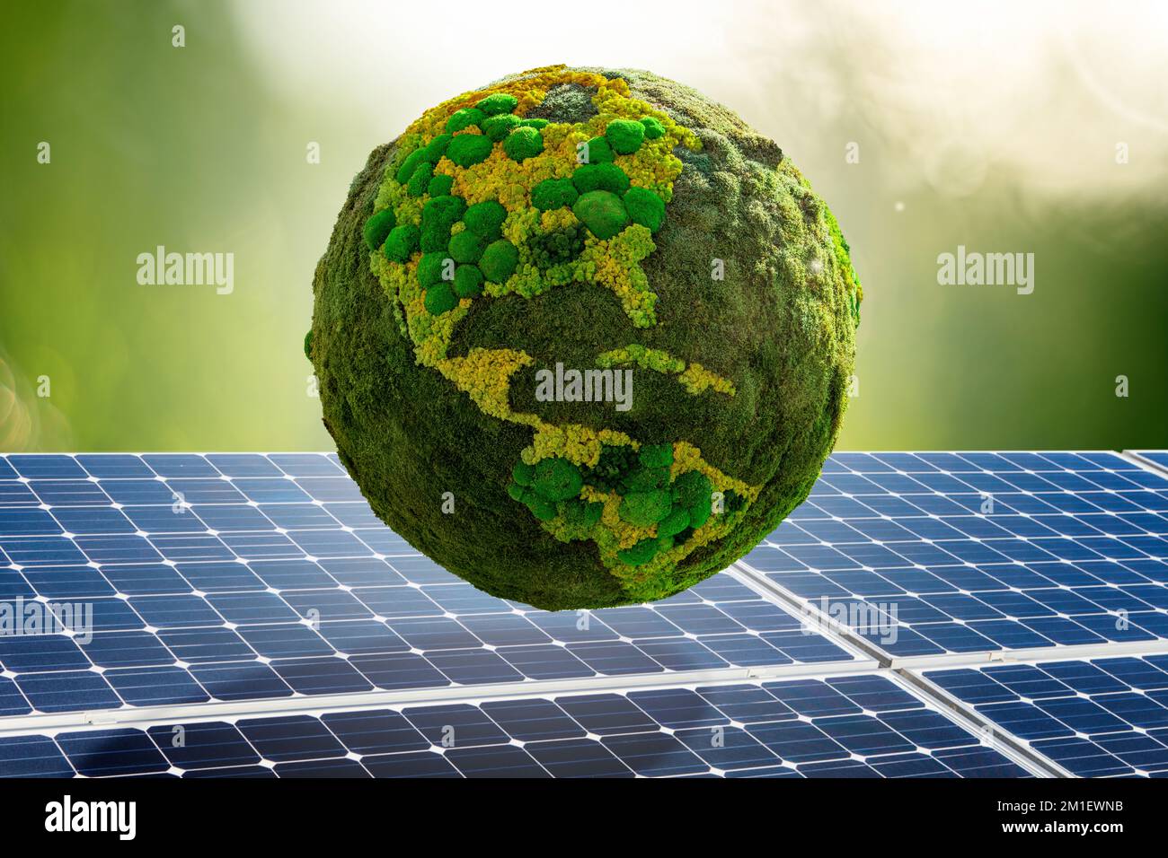 Grüner Planet Erde aus natürlichem Moos auf dem Hintergrund von Solarpaneelen. Symbol für nachhaltige Entwicklung und erneuerbare Energien Stockfoto
