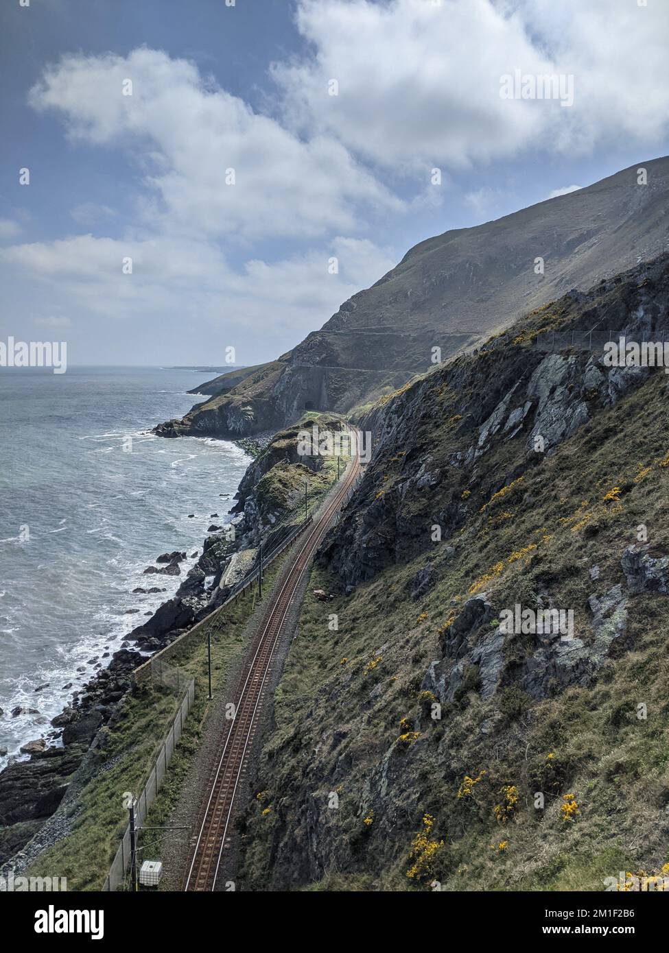 Eisenbahnstrecke an einem wunderschönen Tag zwischen Klippen und Meer an der Küste Irlands in der Nähe von Dublin zwischen Bray und Greystones. Stockfoto
