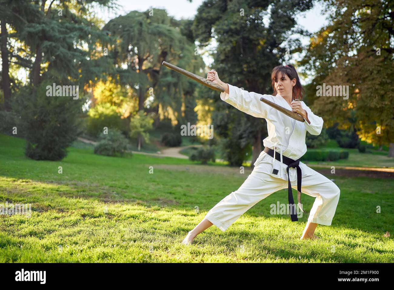 Kampfsportlehrer in weißem Kimono übt mit Tonfa. Hochwertiges Foto Stockfoto