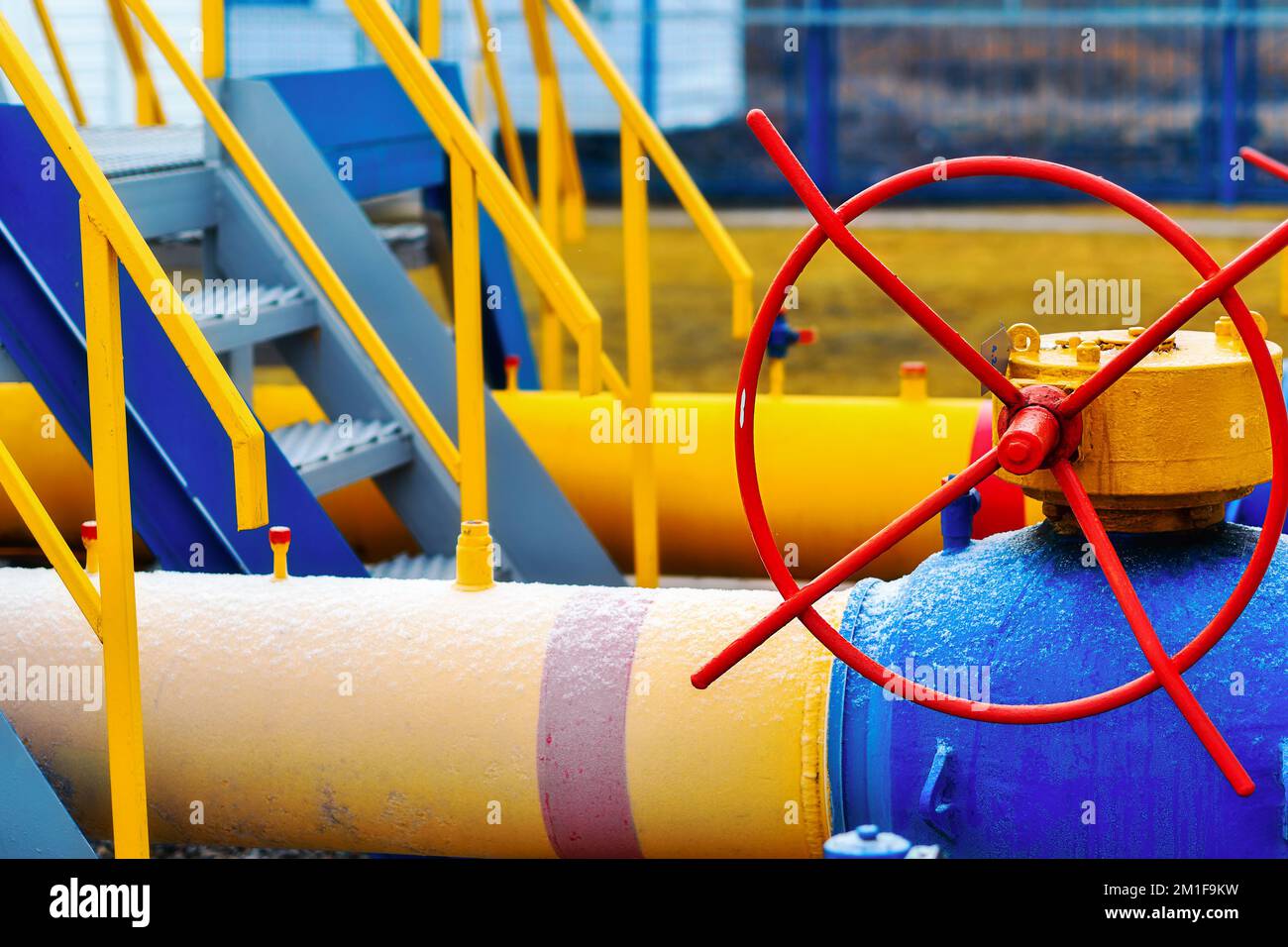 Industrieller Hintergrund. Die Gasleitung ist gelb mit zusätzlichen Anlagen, Rohren und einem Ventil zum Absperren der Gasversorgung. Stockfoto