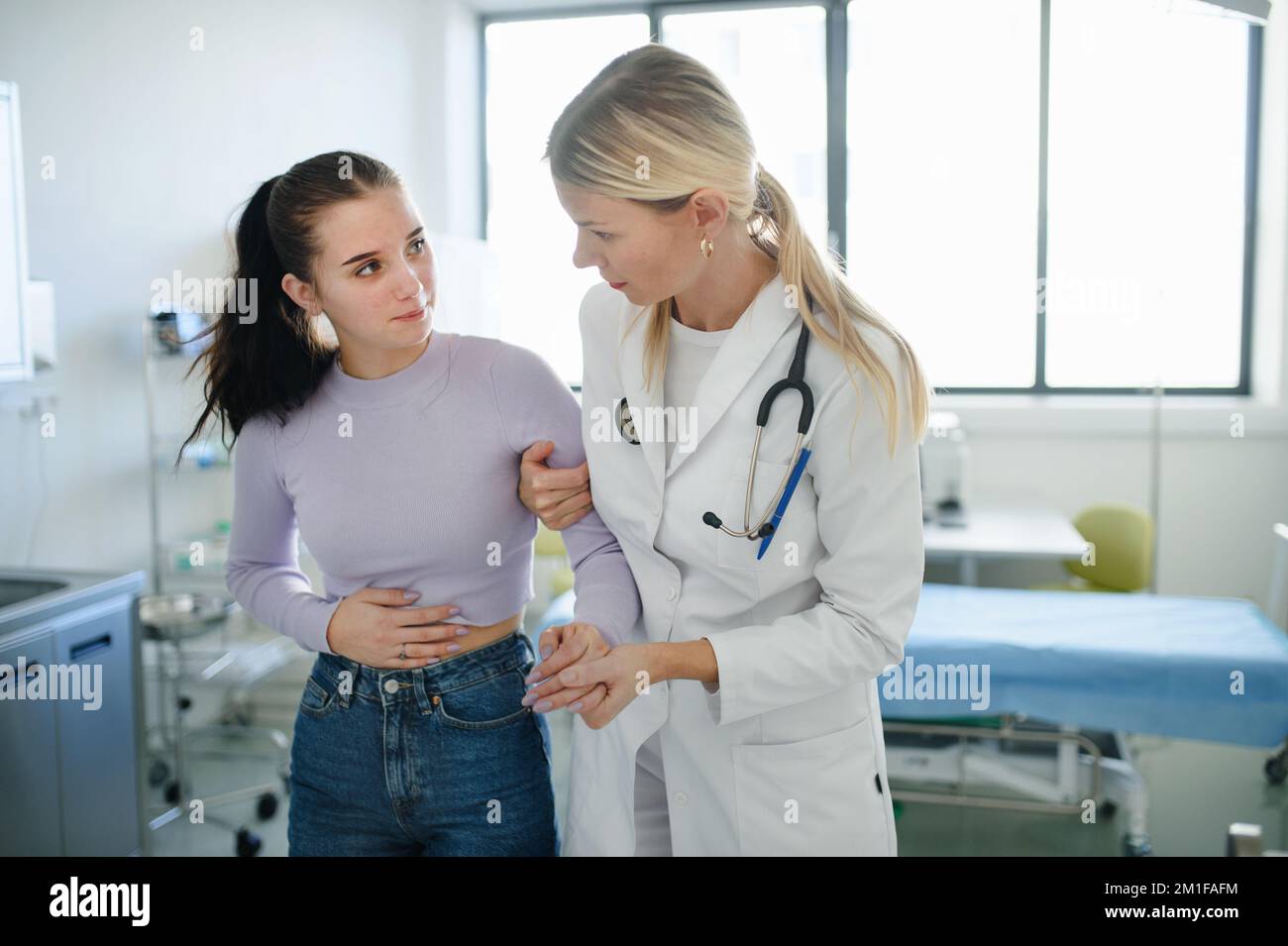 Nahaufnahme eines Arztes, der einem kranken Teenager in ihrer Ambulanz hilft. Stockfoto