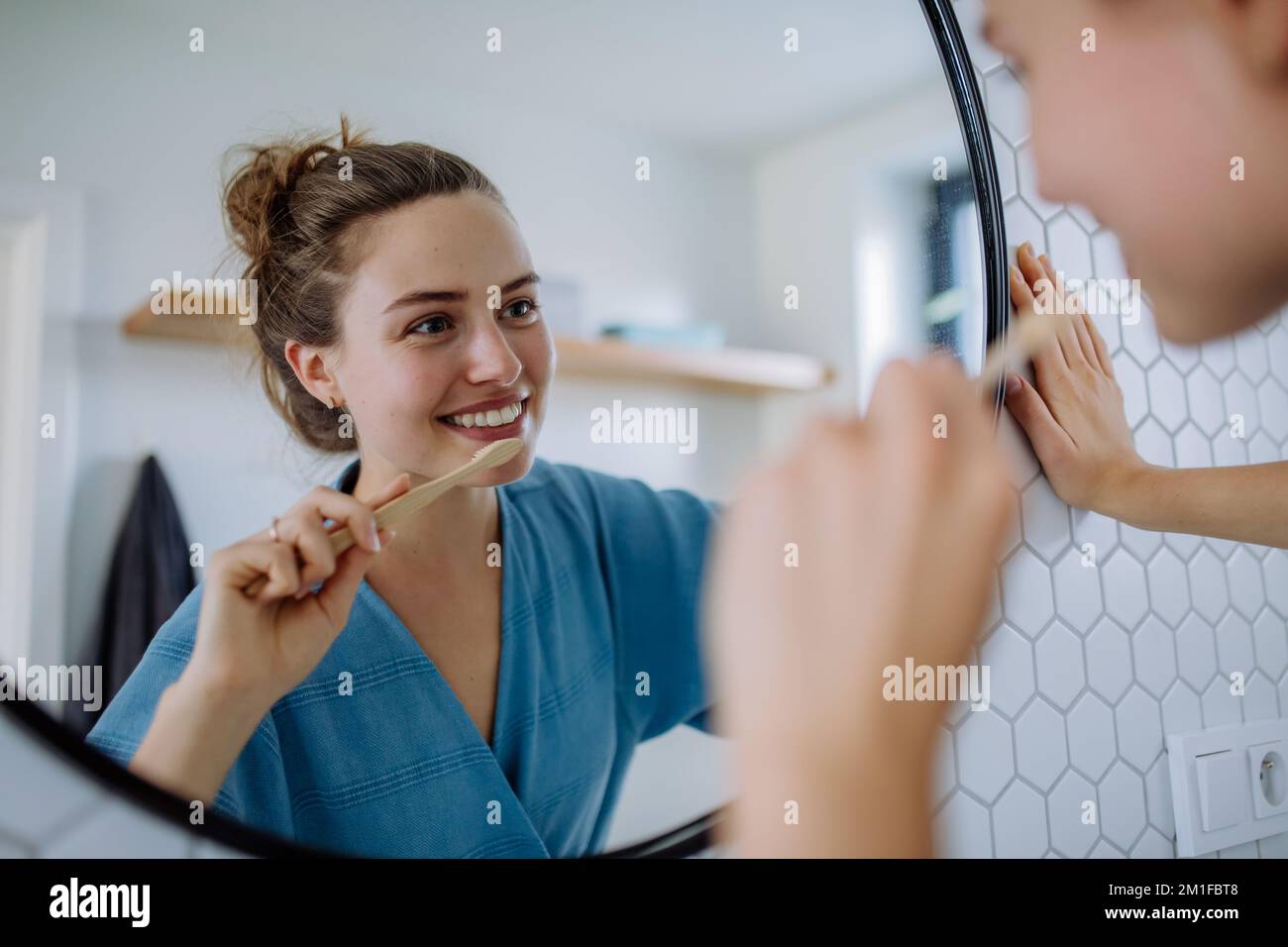 Junge Frau putzt sich die Zähne, morgendliches Routinekonzept. Stockfoto