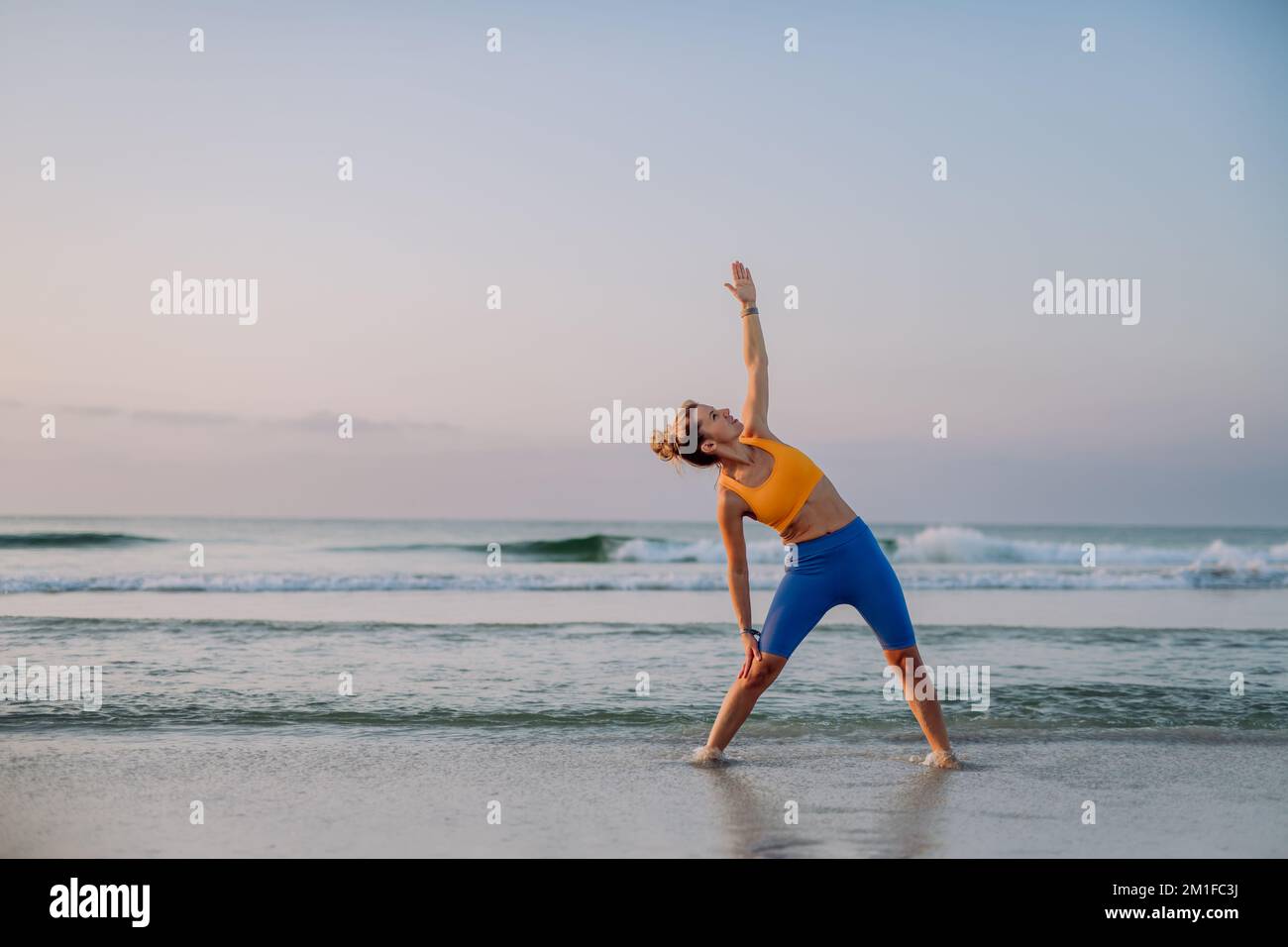 Junge Frau macht Übungen am Strand, Morgenroutine und gesundes Lifestyle Konzept. Stockfoto