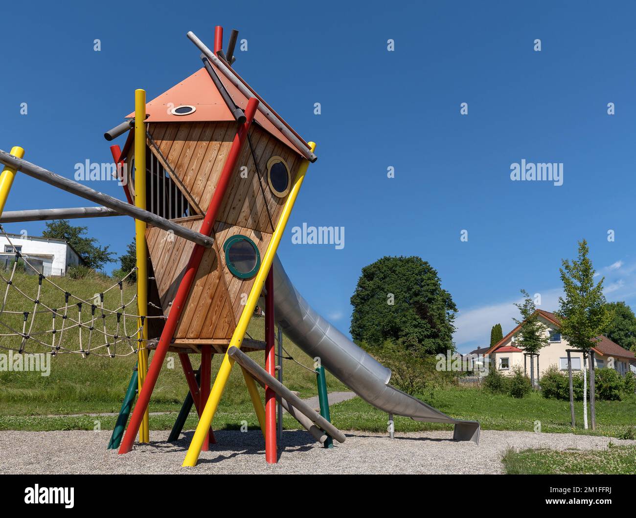 Moderner farbenfroher Spielturm mit Tunnelrutsche auf einem öffentlichen Spielplatz Stockfoto