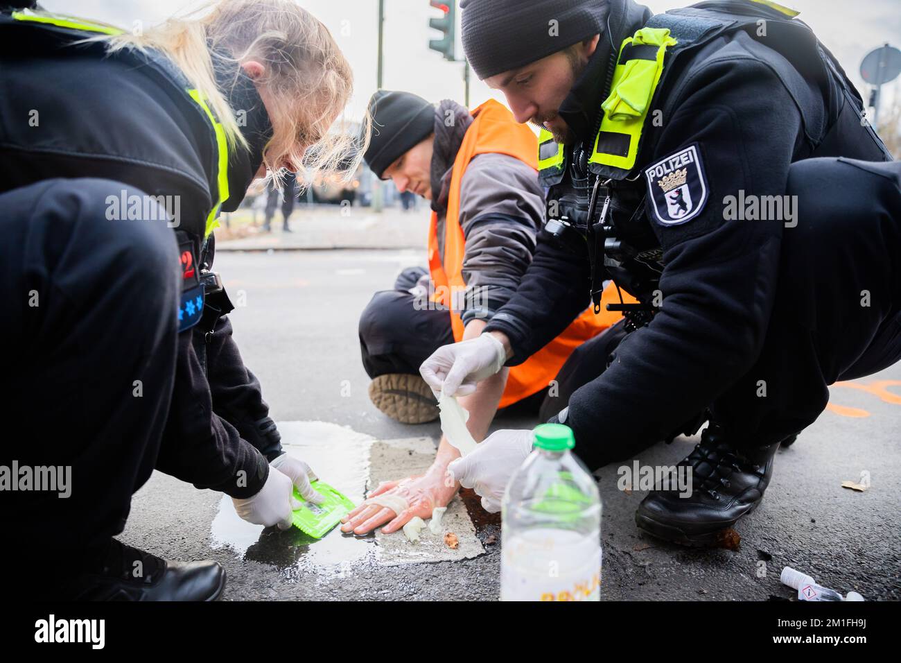 Berlin, Deutschland. 12.. Dezember 2022. Ein Klimaaktivist, der seine Hand an eine Autobahnausfahrt am Innsbrucker Platz geklebt hat, wird von Polizeibeamten freigelassen. Kredit: Christoph Soeder/dpa/Alamy Live News Stockfoto