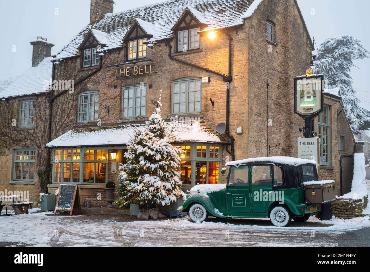 Weihnachtsbaum im Schnee vor dem Bell Pub. Stow on the Wold, Cotswolds, Gloucestershire, England Stockfoto