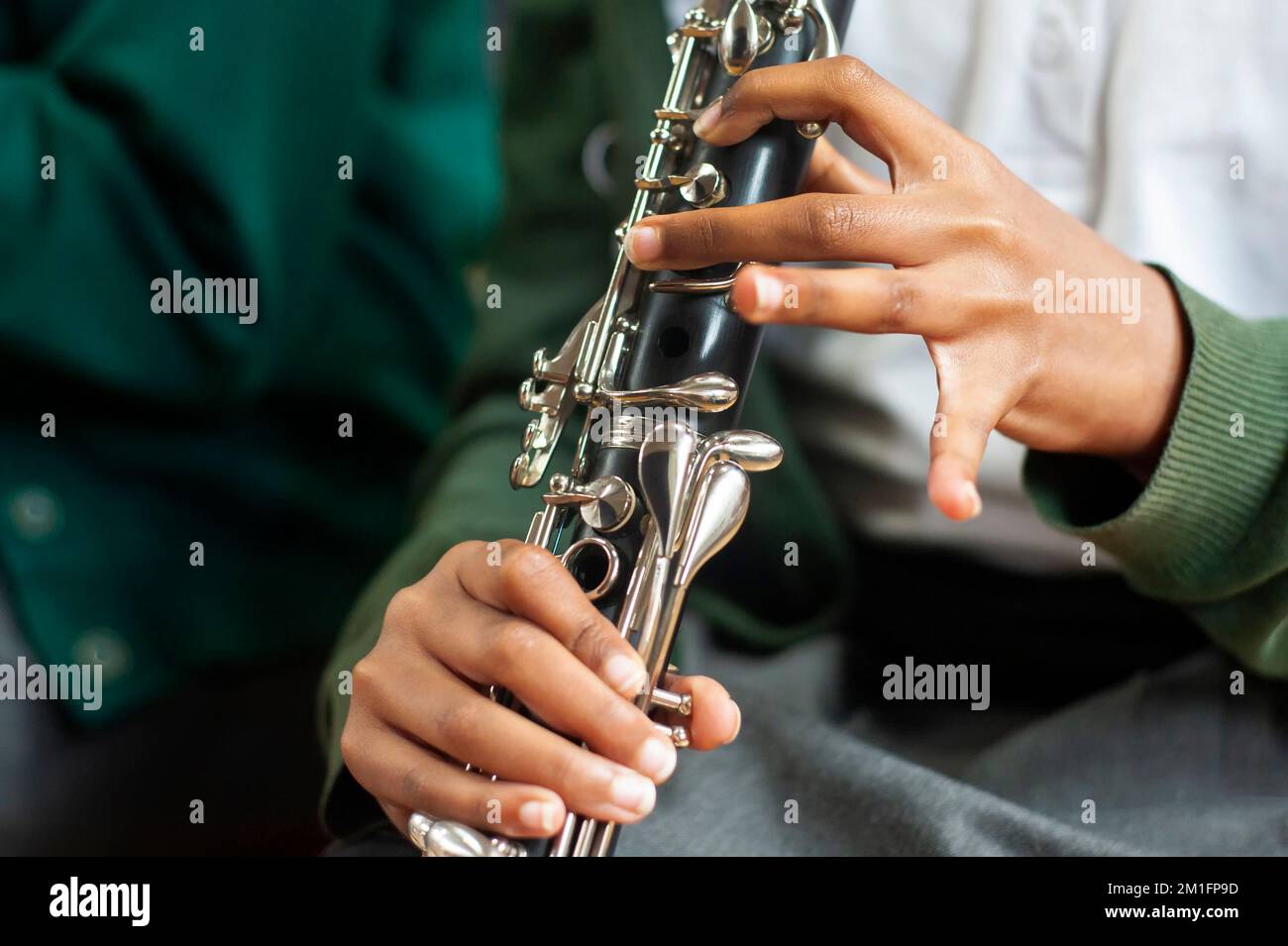 Nahaufnahme der Hände eines Schülers, der Klarinette spielt Stockfoto