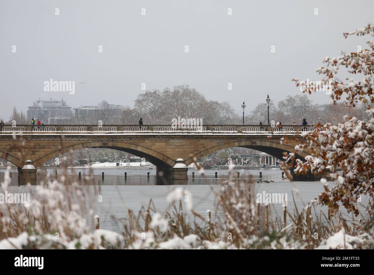 Menschen gehen durch den Schnee im Hyde Park, im Zentrum von London. Schnee und Eis haben sich über Teile Großbritanniens ausgebreitet, und die kalten winterlichen Bedingungen werden tagelang anhalten. Foto: Montag, 12. Dezember 2022. Kredit: Isabel Infantes/Alamy Live News Stockfoto