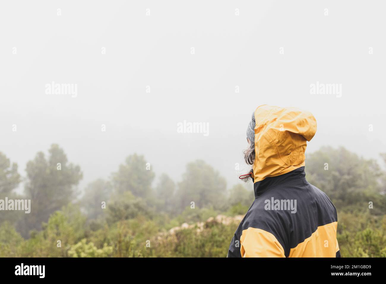 Wanderer auf dem Rücken atmen frische Luft hoch in den Bergen an einem nebligen Tag Stockfoto
