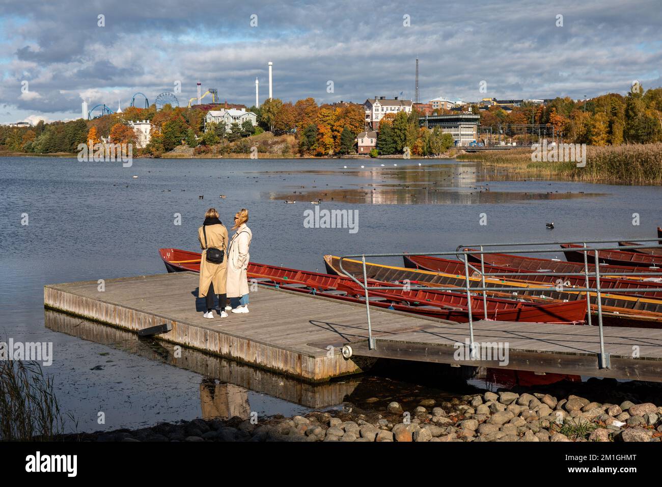 Frauen stehen auf einem Steg an der Töölönlahti Bay in Helsinki, Finnland Stockfoto