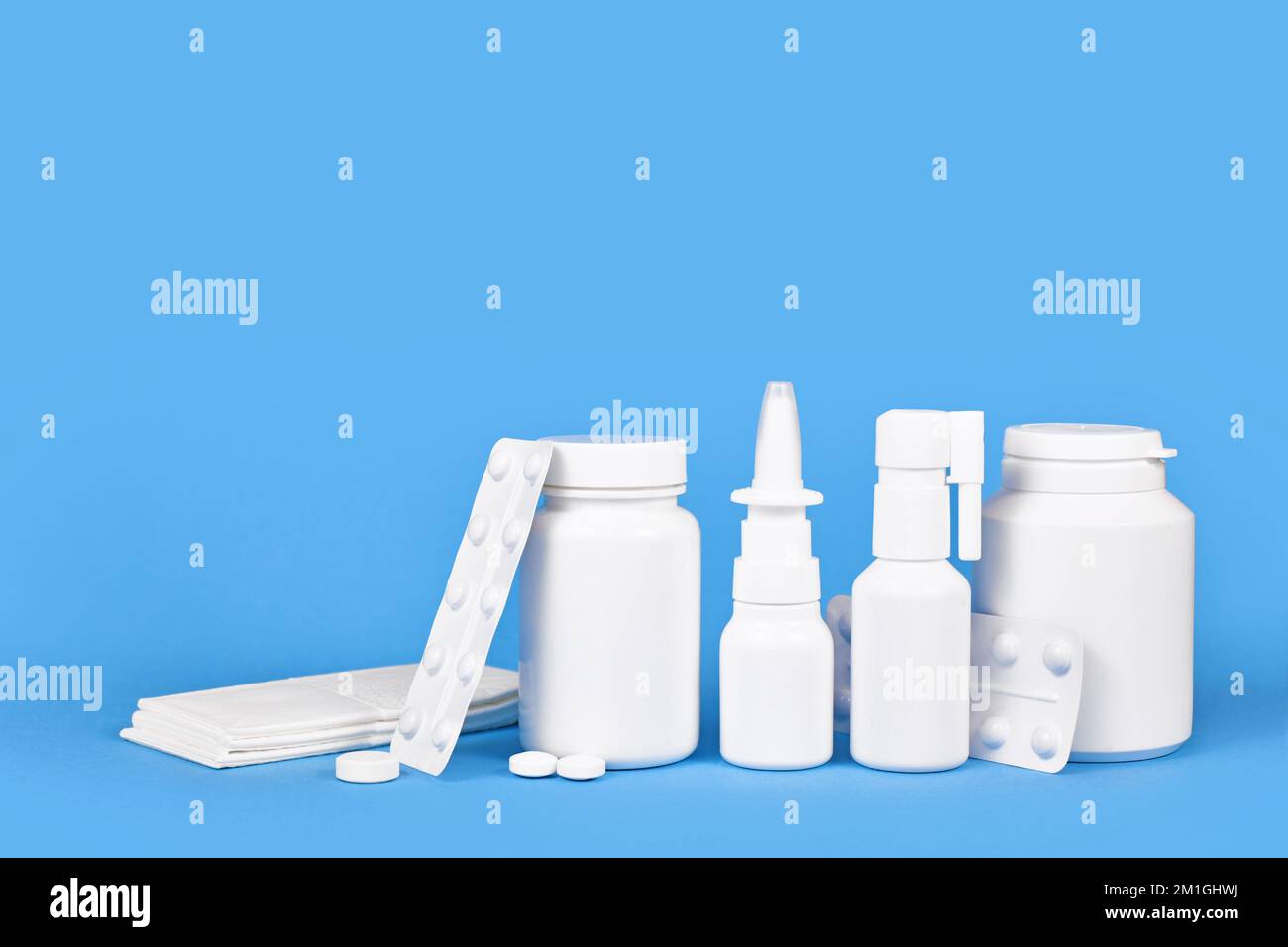 Kälte- und Rauchmedikation. Nasenspray, Rachenspray, Pillen und Taschentücher auf blauem Hintergrund mit Kopierbereich Stockfoto