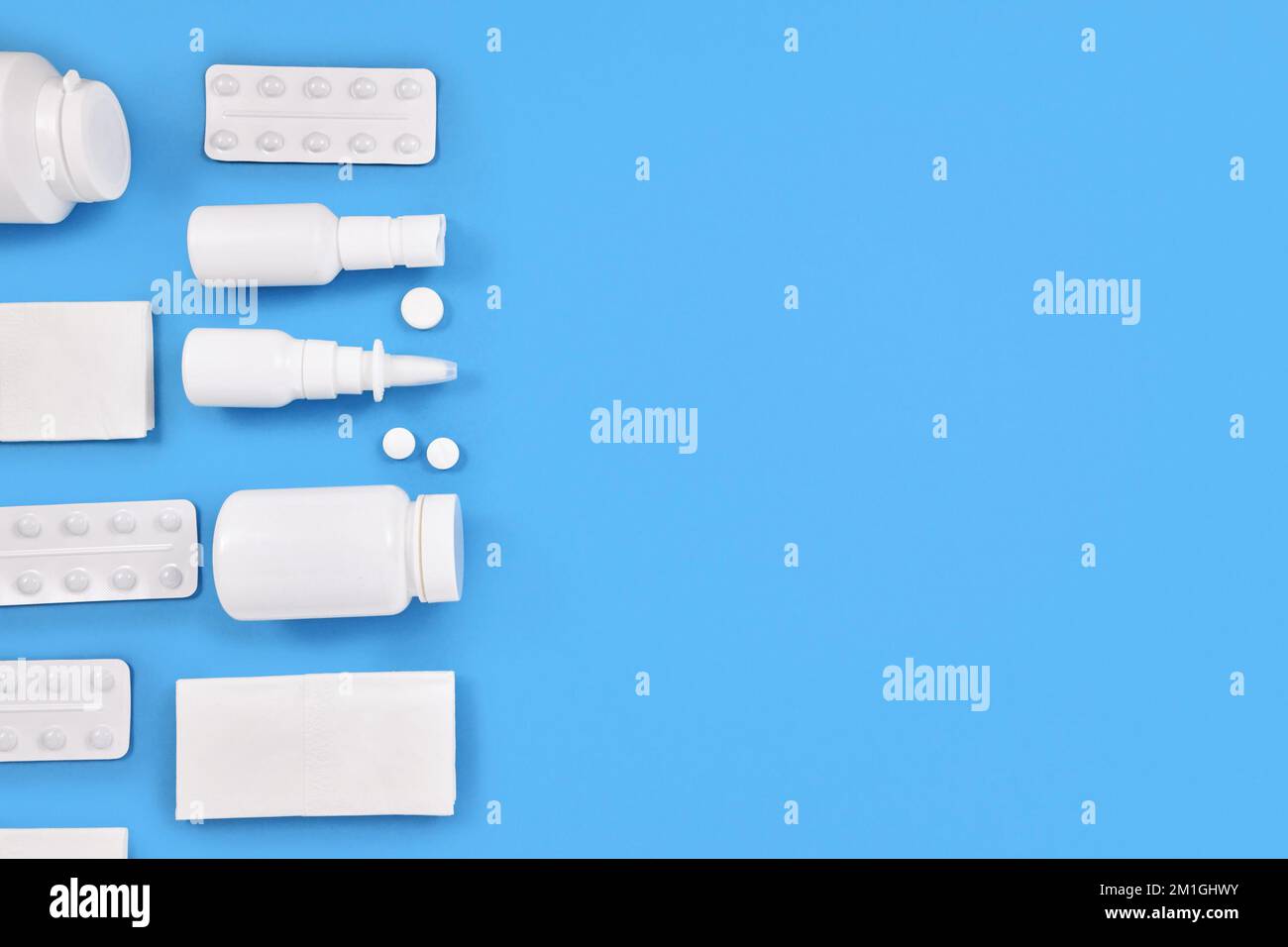 Kälte- und Rauchmedikation. Nasenspray, Rachenspray, Pillen und Taschentücher auf blauem Hintergrund mit Kopierbereich Stockfoto