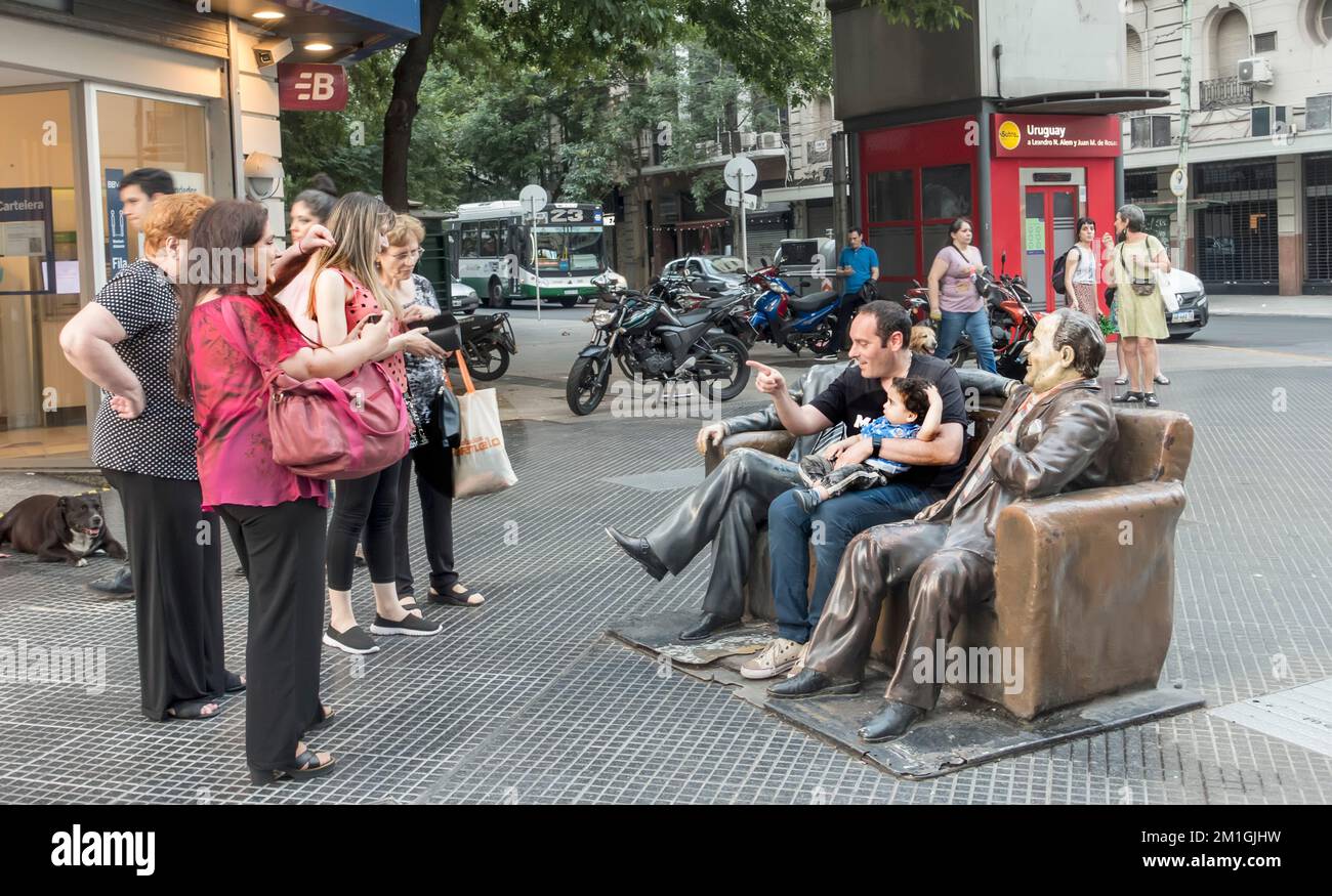 Ein Familienfoto auf dem Smartphone ein Vater und Sohn auf einer Statue berühmter Menschen in Buenos Aires, Argentinien Stockfoto