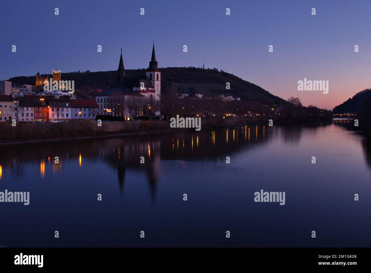 Bingen am Rhein, Deutschland - 10. Januar 2021: Farbenfroher Himmel über Schloss Klopp, Kirche und Brücke mit ihren Reflexionen im Rhein im Winter n Stockfoto