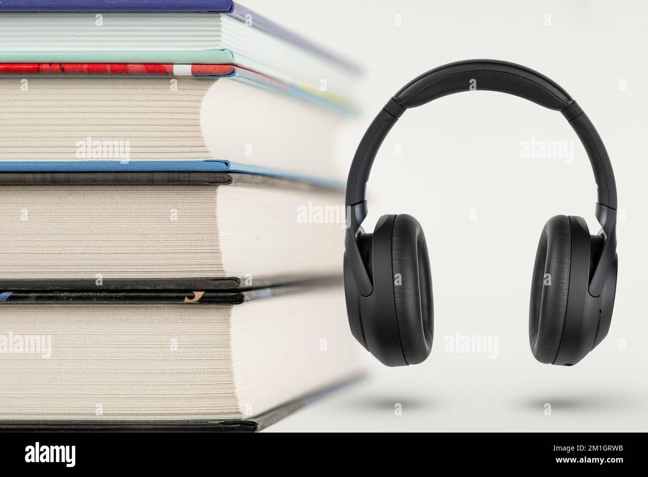 Hörbücher. Hörbuchkonzept, Bücherstapel und Kopfhörer mit Platz für Kopien. Auswahl zwischen Büchern und Audio. Stockfoto