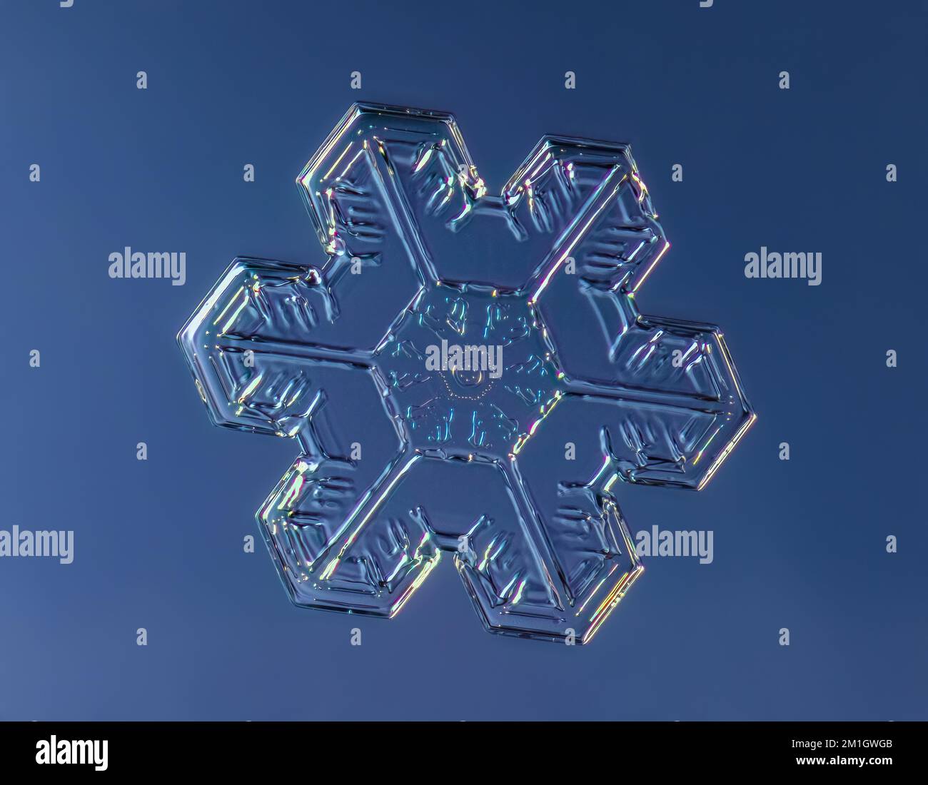 Schneeflocke auf gleichmäßigem Hintergrund. Makrofoto eines echten Schneekristalls auf Glasoberfläche. Das ist ein kleiner Schneeflockenkristall mit ungewöhnlichem Muster Stockfoto