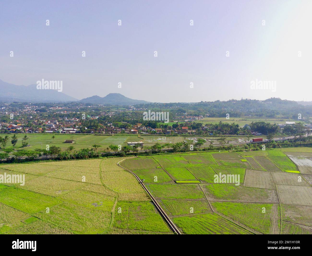 Ein Blick auf die Reisfelder mit dem Stadtbild von Ambarawa und den Bergen im Hintergrund Stockfoto