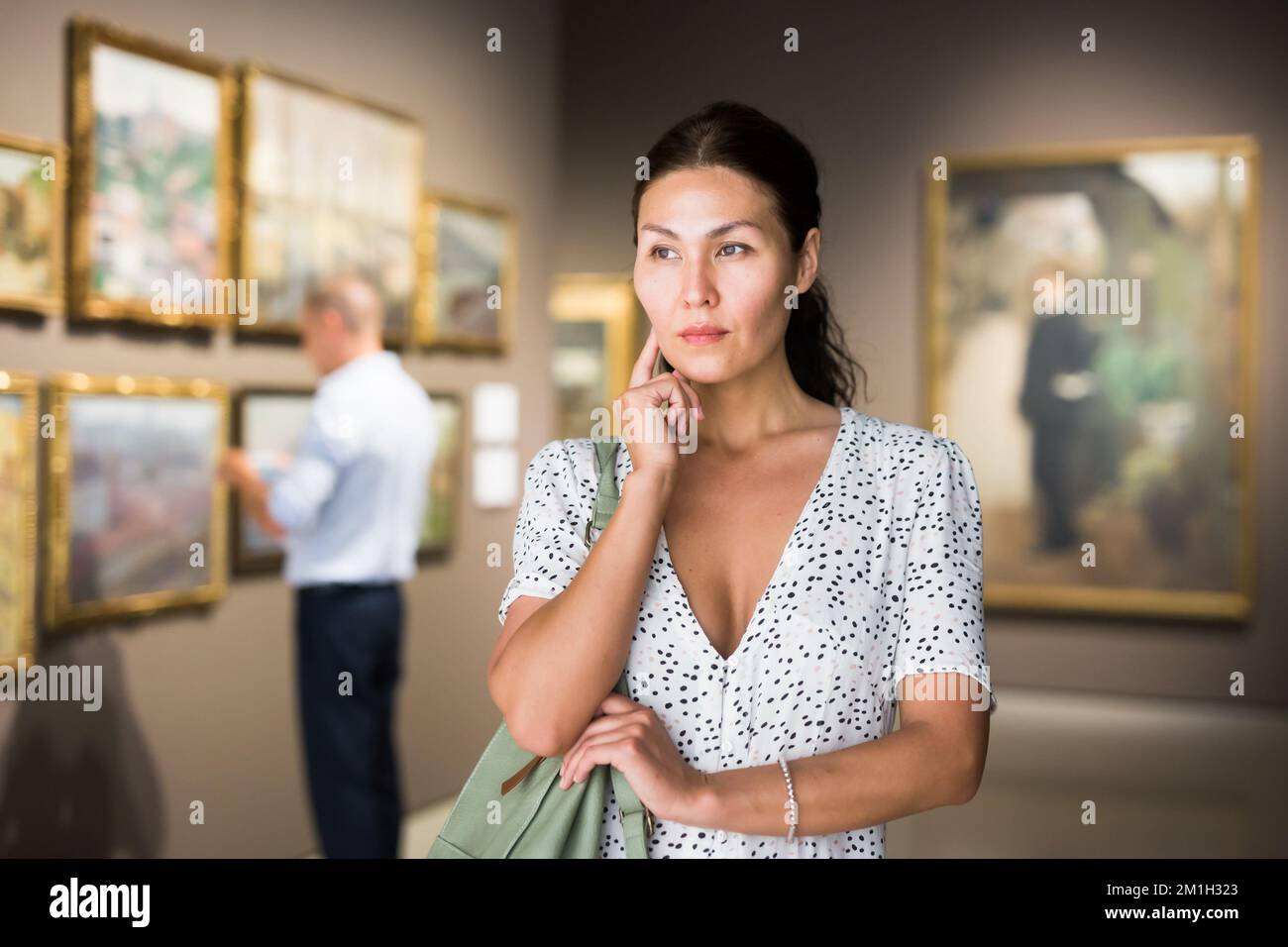 Frau bewundert Kunstwerke Stockfoto