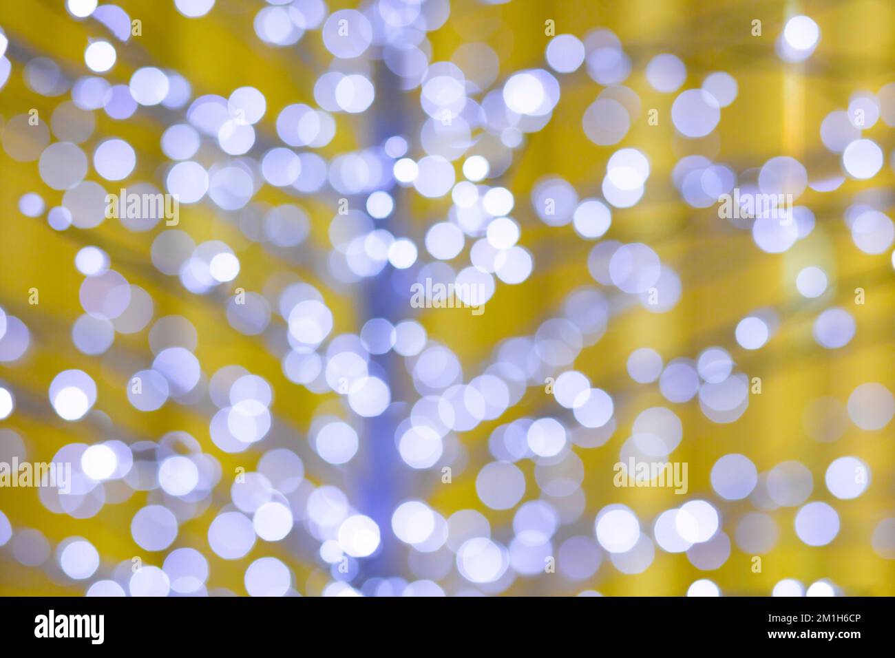 Unscharfe weihnachtslichter, gelber Hintergrund, blauer Farbton Stockfoto