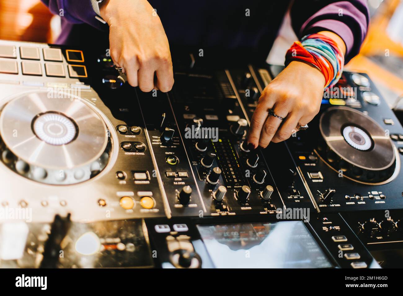 DJ spielt Live-Set und mischt Musik auf der Plattenkonsole auf der Bühne im Nachtclub. Disc Jockey hat einen Soundmixer auf einer Club-Party. DJ-Mixer (Forts. Stockfoto