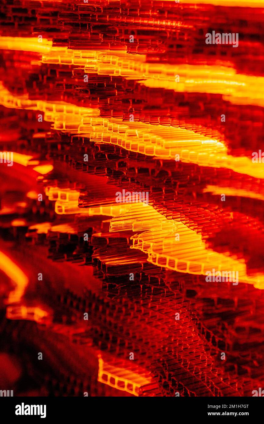 Orangefarbenes futuristisches vertikales brennendes Feuer Abstraktes Hightech-Konzept mit welligen geomentrikulären leuchtenden Elementen. Stockfoto