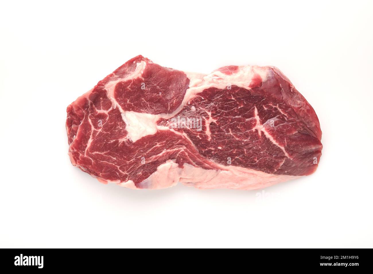 Rohes Steak, isoliert auf Weiß. In Scheiben gegrilltes Fleischsteak New York oder Ribeye mit Gewürzen, Rosmarin und Pfeffer auf weißem Hintergrund. Draufsicht. Modell. Stockfoto