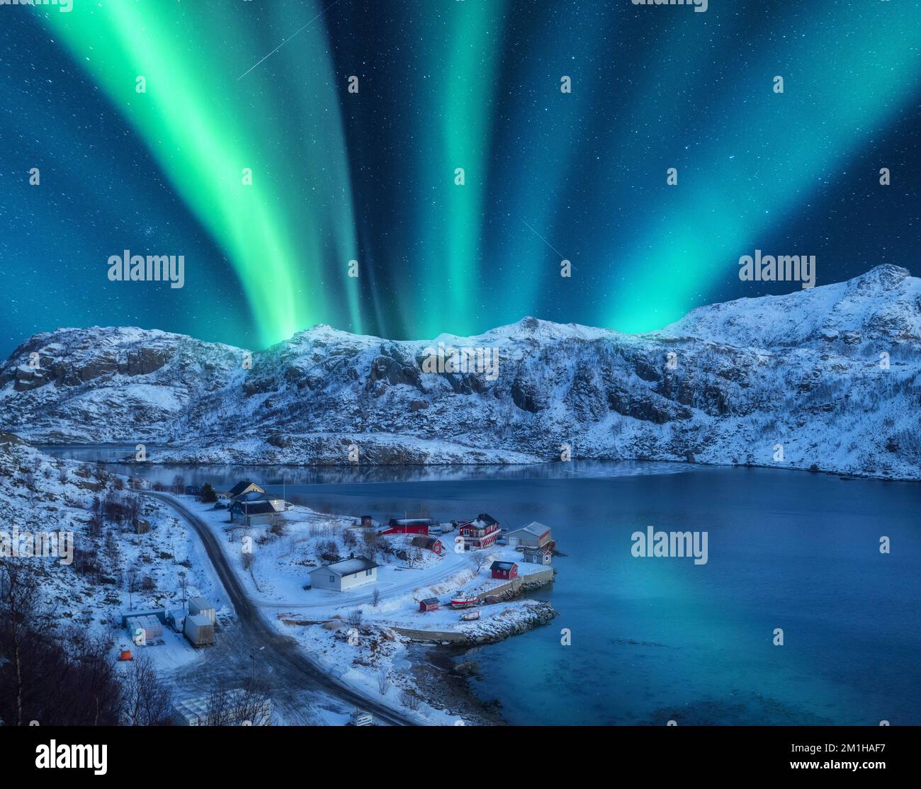 Polarlichter über den schneebedeckten Bergen, Meer bei Nacht in den Lofoten Stockfoto