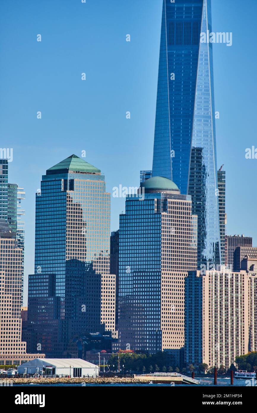 Details der vertikalen Wolkenkratzer von New York City mit reflektierendem Glas und blauem Himmel Stockfoto