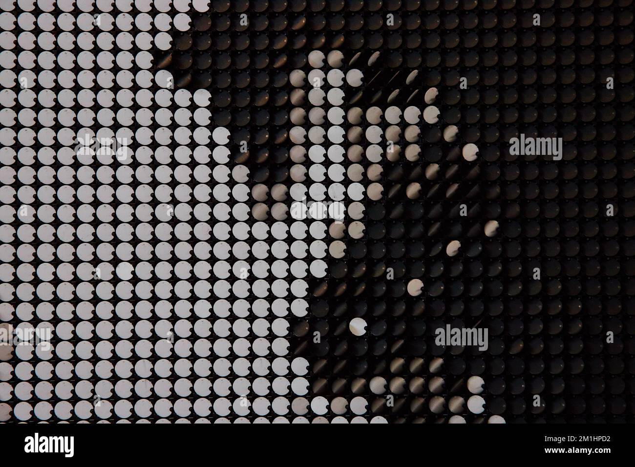 Abstrakte Textur schwarz-weißer Flip-Stücke an der Wand Stockfoto