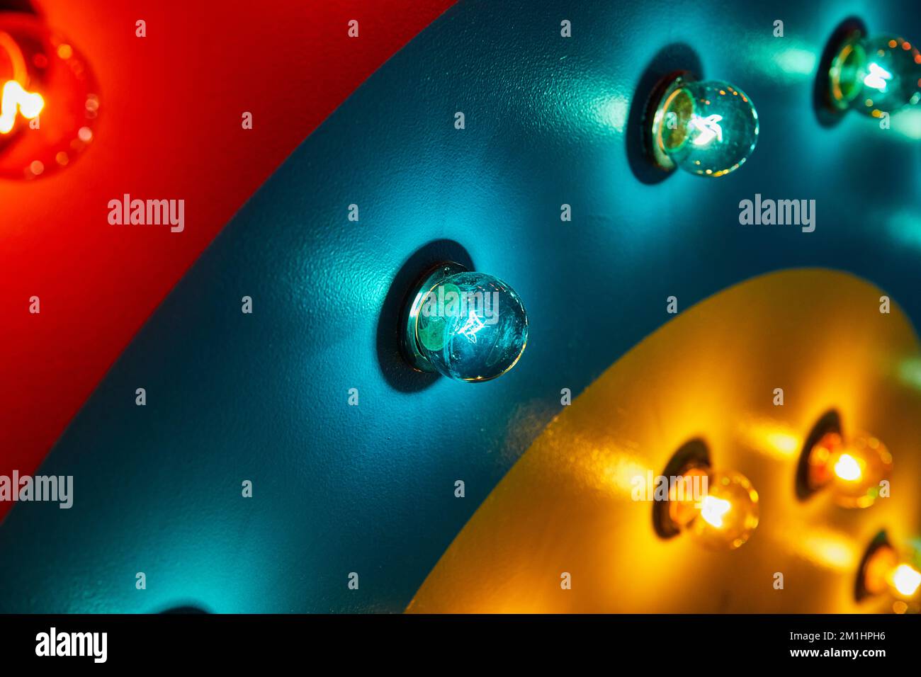 Rote, blaugrüne und gelbe Wand mit Lampenabdeckung Stockfoto