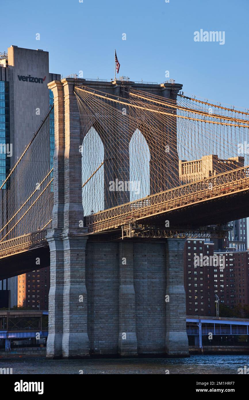 Details der Brooklyn Bridge in goldenem Licht mit Skyline im Hintergrund Stockfoto