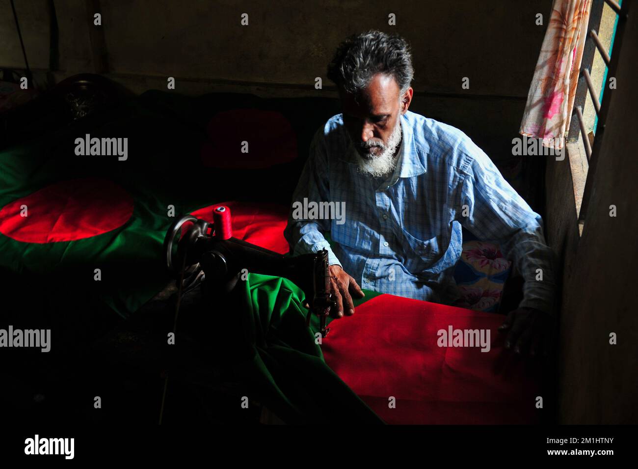 12. Dezember 2022 Sylhet-Bangladesch: Ein 55-jähriger Schneider Kaosar Khan von Sylhets Loharpara, der die Nationalflagge von Bangladesch näht. Etwa die Hälfte der Tausenden von Nationalflaggen, die er näht und die das ganze Jahr über im Dezember verkauft werden. Bangladesch hat im bewaffneten Befreiungskrieg vor 51 Jahren in diesem Dezember 1971 den Sieg errungen . Im Austausch für 3 Millionen Leben und Ehre von 200.000 Frauen in neun Monaten Krieg kam dieser Moment am 16. Dezember. Bangladesch feiert diese Errungenschaft noch immer mit der gebührenden würde. Am 12. Dezember 2022 in Sylhet, Bangladesch (Foto: MD Rafayat Haque Khan/Eyepix Group) Stockfoto