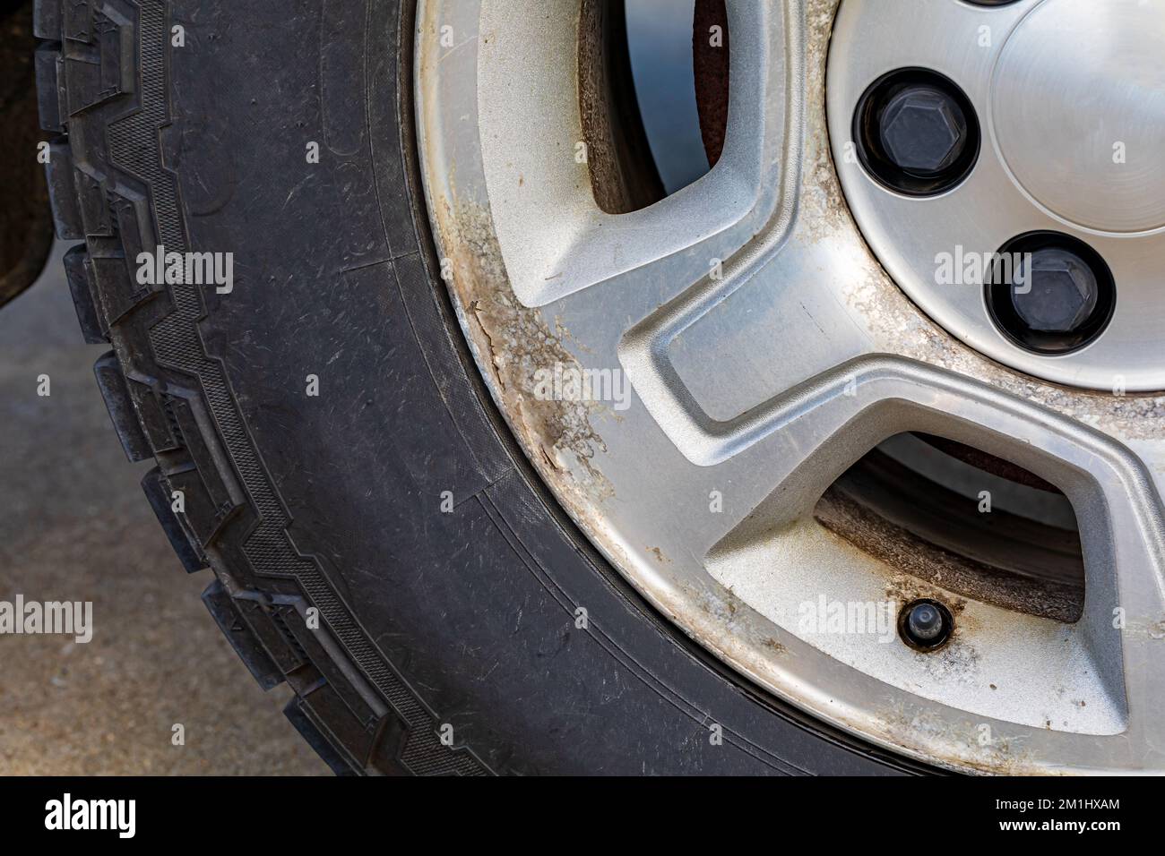 Altes, korrodiertes Aluminiumrad am Fahrzeug. Kfz-Instandhaltungs-Reparatur- und Kfz-Pflegekonzept. Stockfoto