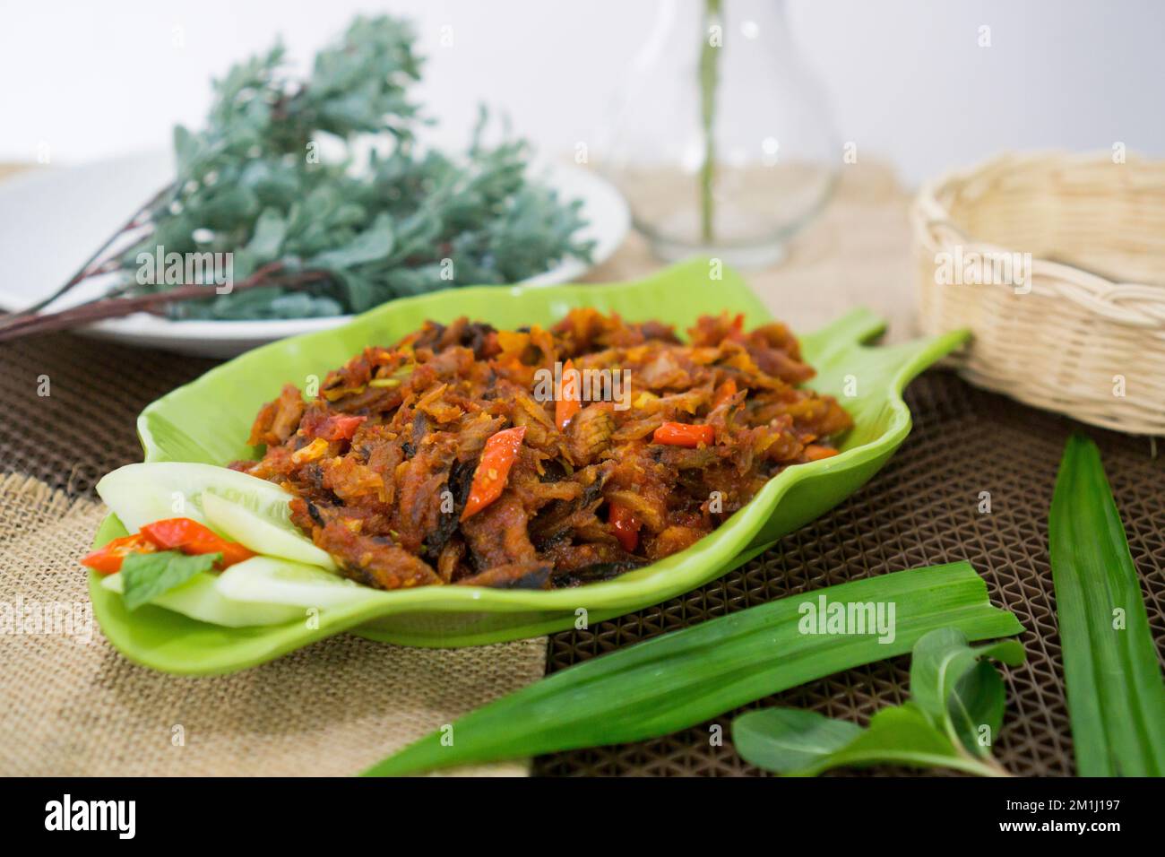 Pampis Tongkol/Cakalang, Manados traditionelles Fischgericht mit scharfem Fisch, serviert auf grünem Teller Stockfoto