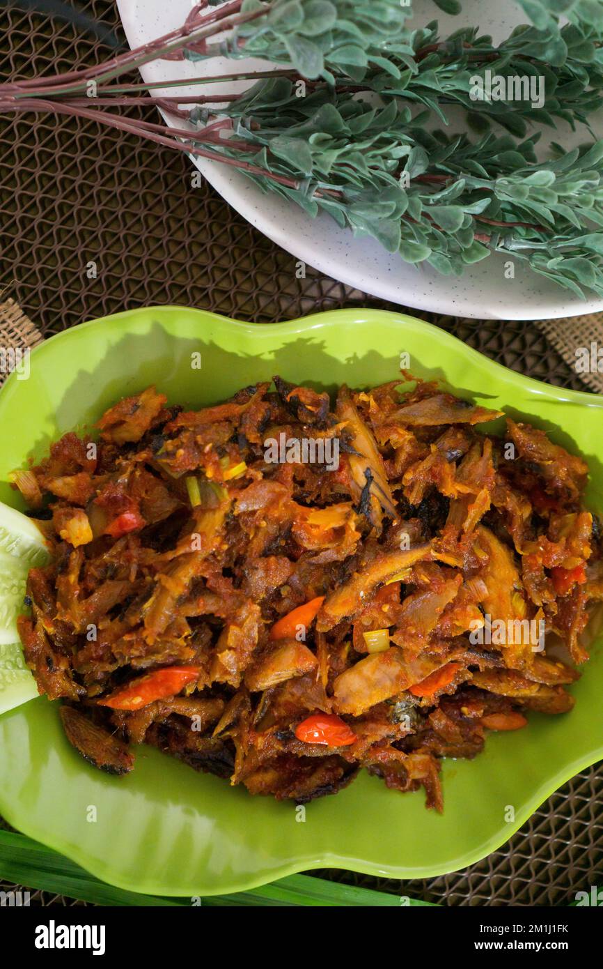 Pampis Tongkol/Cakalang, Manados traditionelles Fischgericht mit scharfem Fisch, serviert auf grünem Teller Stockfoto