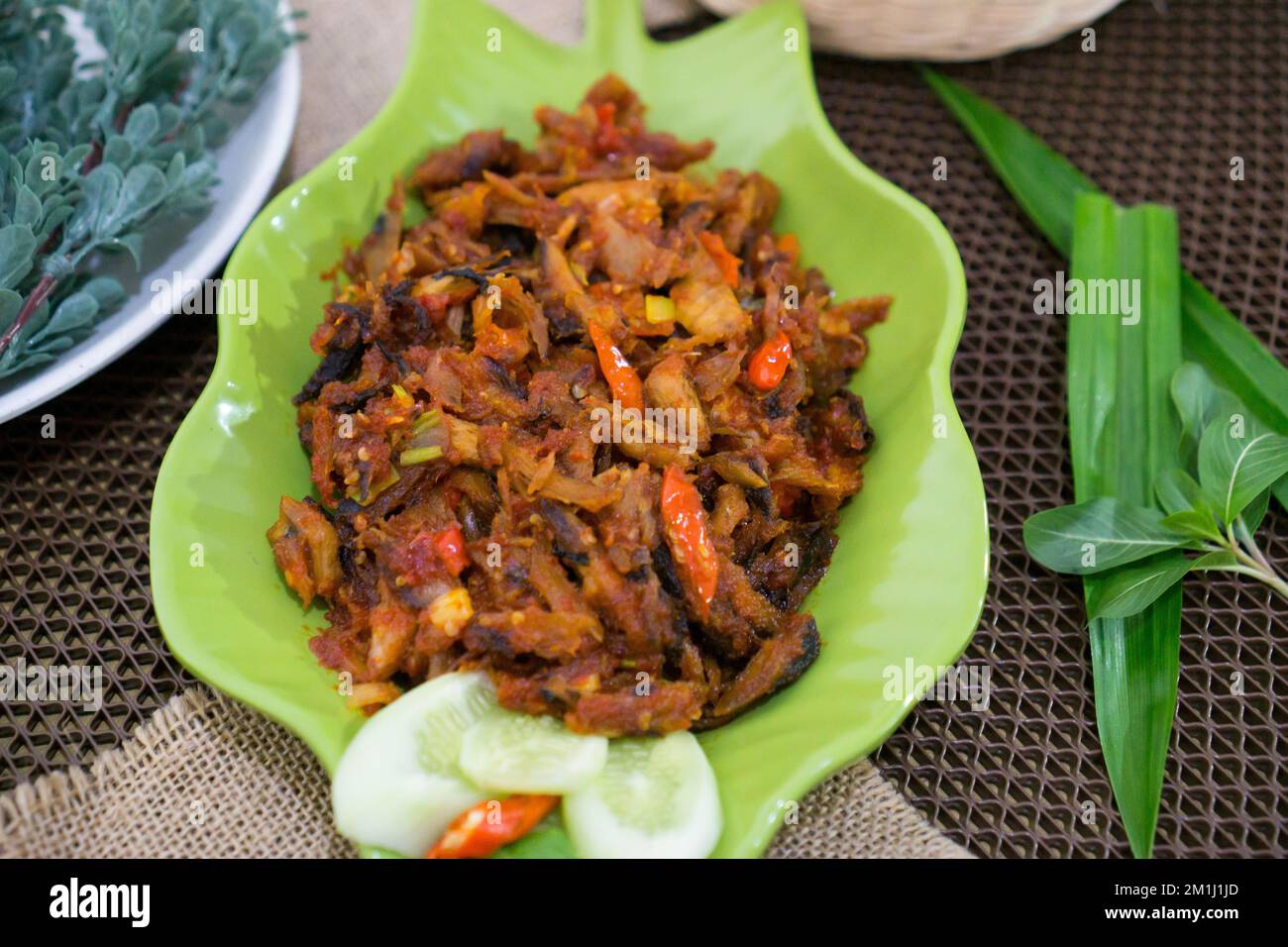 Pampis Tongkol/Cakalang, Manados traditionelles Fischgericht mit scharfem Fisch, serviert auf grünem Teller Stockfoto