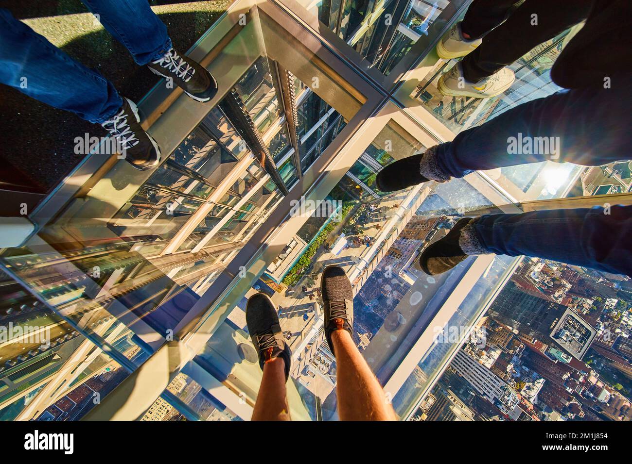 Blick auf den Glasbodenaufzug New York City mit drei Paar Touristenfüßen und Balkon darunter Stockfoto