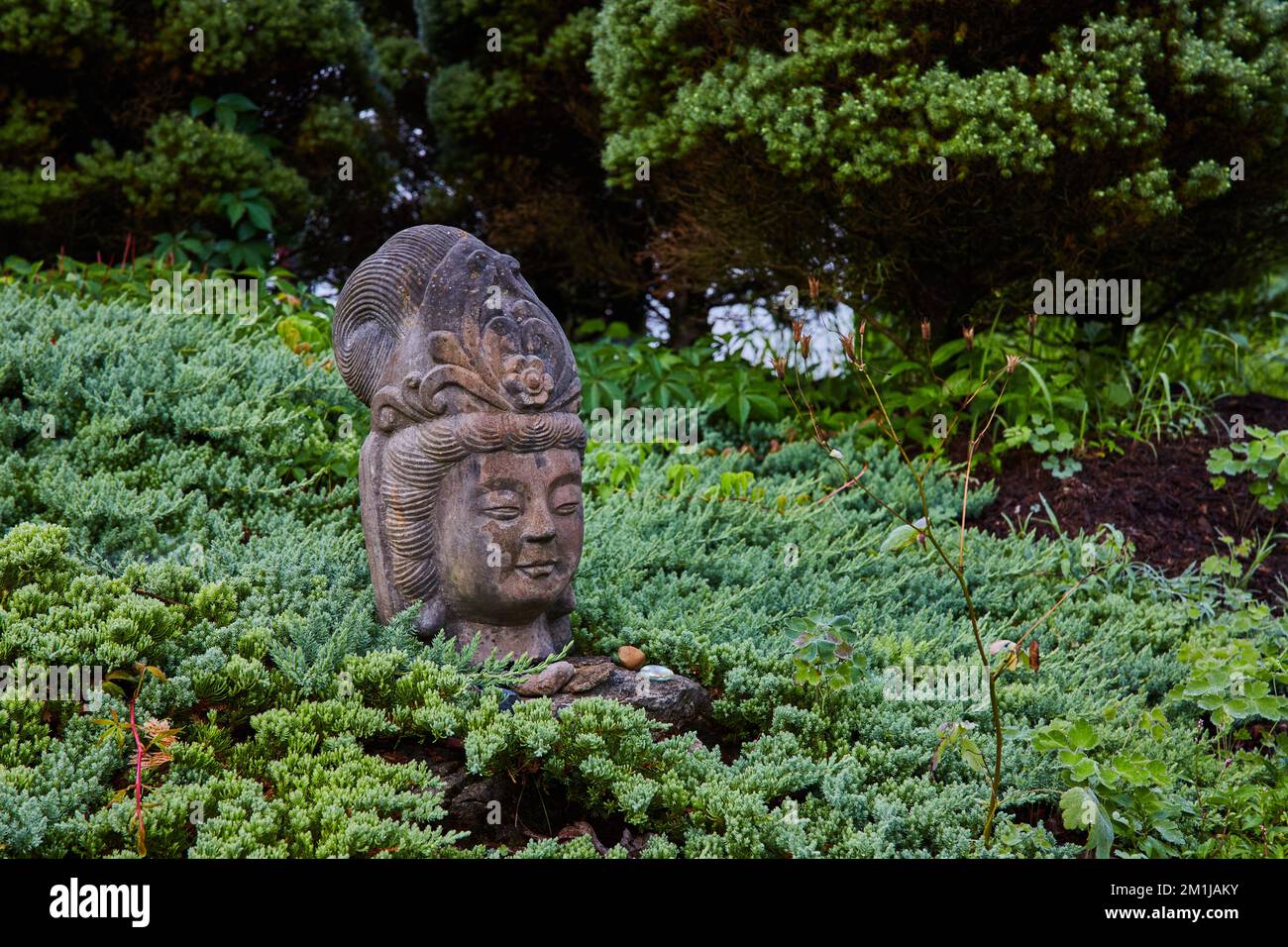 Der alte tibetische mongolische buddhistische Steinkopf in den Gärten Stockfoto